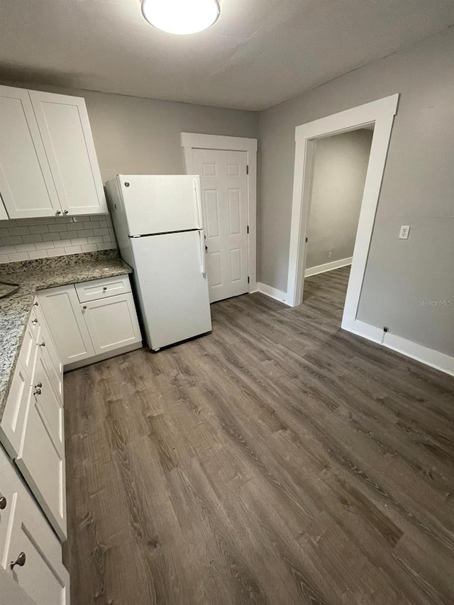 kitchen featuring decorative backsplash, white cabinetry, white fridge, and dark hardwood / wood-style floors