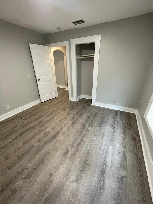 unfurnished bedroom featuring a closet and hardwood / wood-style floors