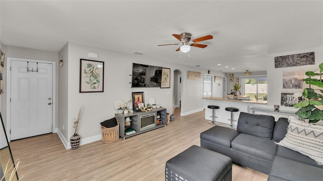 living room featuring light hardwood / wood-style floors and ceiling fan