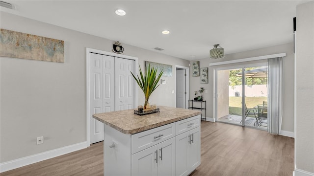 kitchen featuring white cabinetry, a kitchen island, and light wood-type flooring