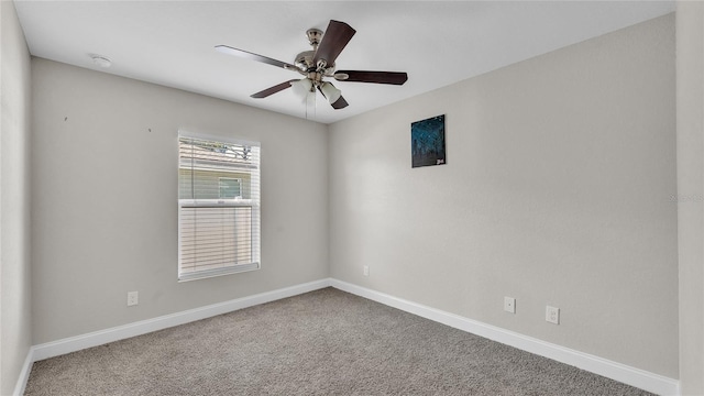 carpeted spare room featuring ceiling fan