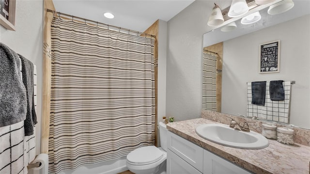 bathroom with walk in shower, vanity, and toilet