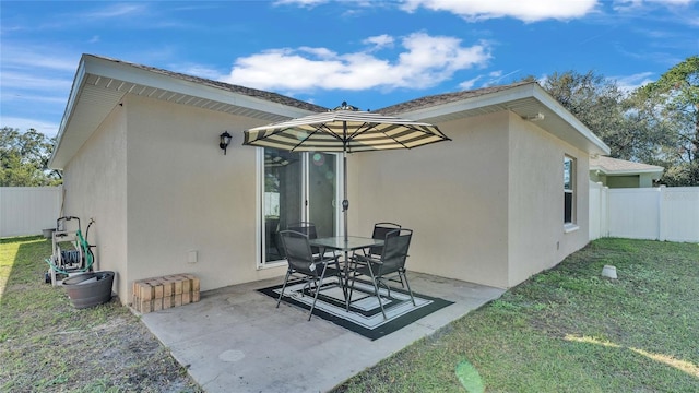 rear view of property with a yard and a patio