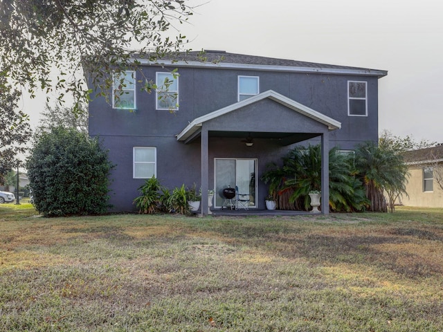 back of house featuring a lawn