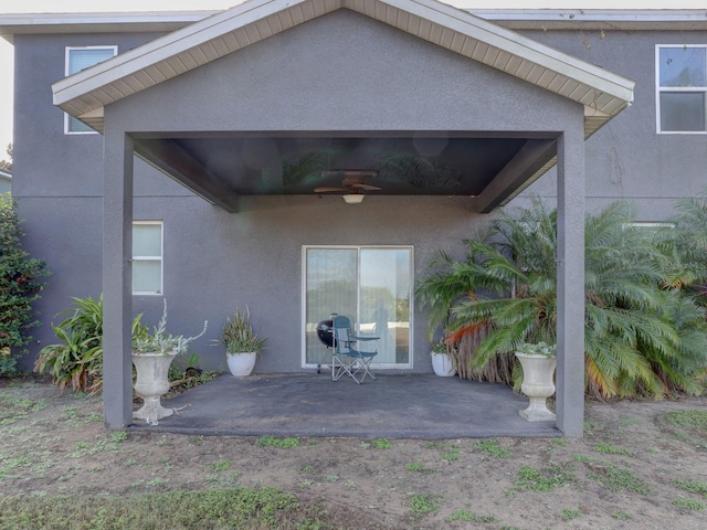 entrance to property with ceiling fan and a patio