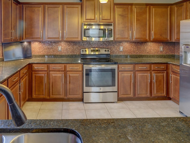 kitchen featuring decorative backsplash, light tile patterned flooring, and stainless steel appliances