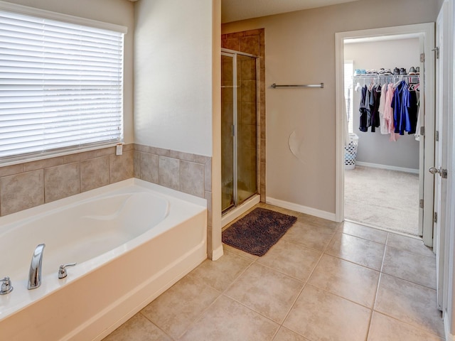 bathroom with tile patterned flooring and shower with separate bathtub