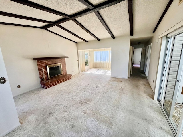 unfurnished living room with lofted ceiling with beams, a textured ceiling, and a brick fireplace