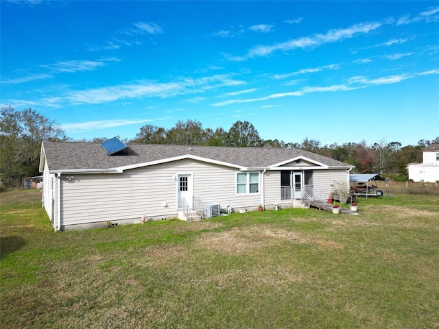 rear view of property with a lawn and central air condition unit