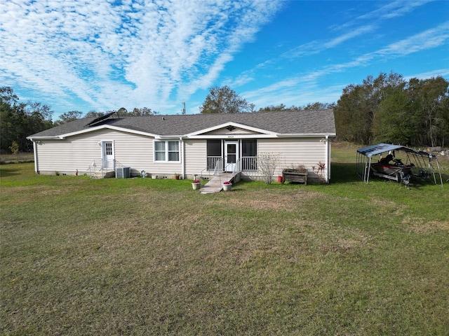 back of house with cooling unit, a carport, and a lawn