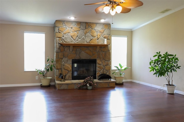 living room featuring ornamental molding, a stone fireplace, dark hardwood / wood-style floors, and ceiling fan