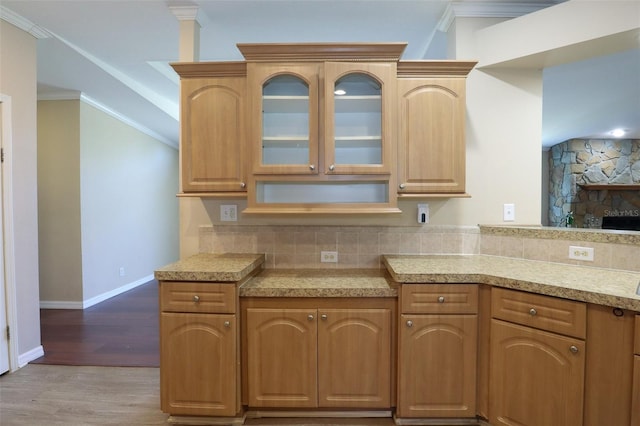 kitchen featuring hardwood / wood-style floors, backsplash, and ornamental molding