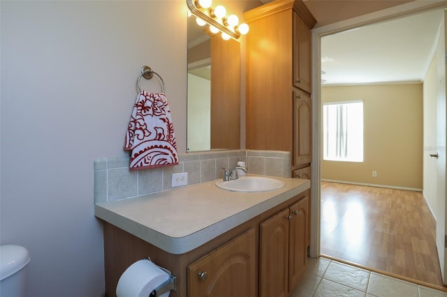 bathroom with tasteful backsplash, vanity, crown molding, and toilet