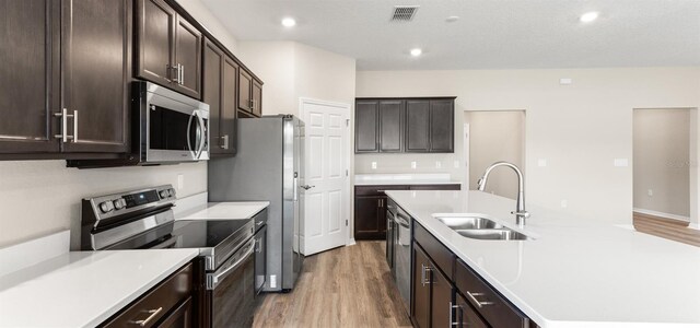 715 SW 77th Cir, Ocala, FL 34474 - kitchen with appliances with stainless steel finishes, a sink, light wood finished floors, an island with sink, and recessed lighting
