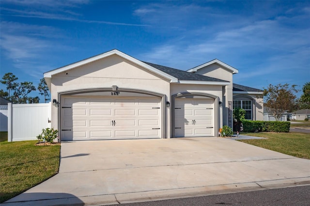 ranch-style home with a garage and a front lawn