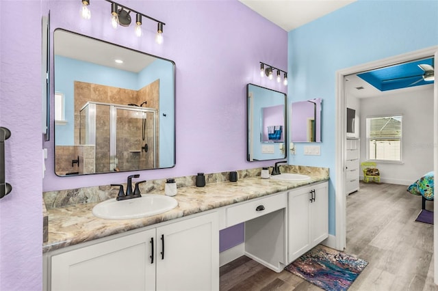 bathroom with vanity, hardwood / wood-style flooring, a shower with shower door, and ceiling fan