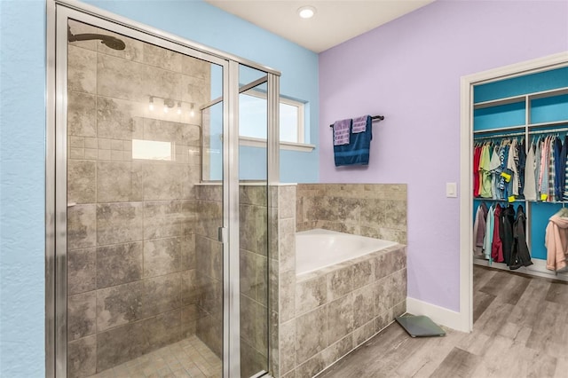 bathroom with hardwood / wood-style flooring and separate shower and tub