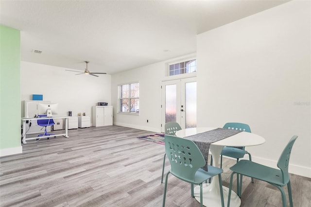 dining room with french doors and light hardwood / wood-style flooring