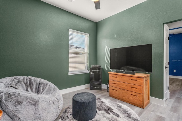 living area featuring ceiling fan and light hardwood / wood-style flooring