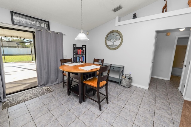 tiled dining space featuring vaulted ceiling