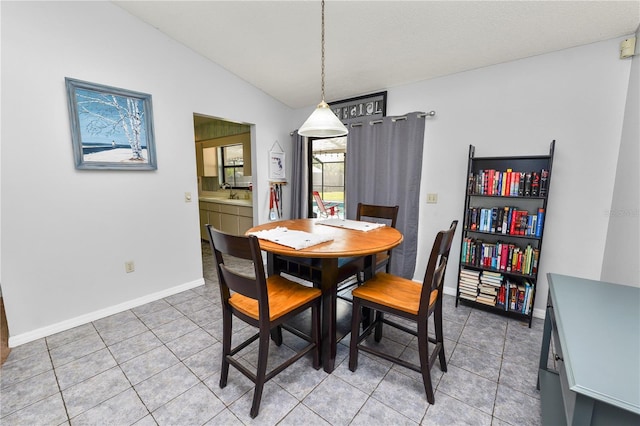 dining room with tile patterned flooring, sink, and vaulted ceiling