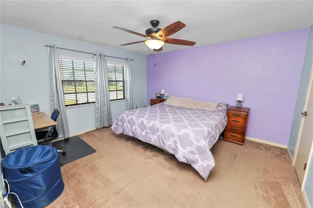 bedroom with ceiling fan, light colored carpet, and a textured ceiling