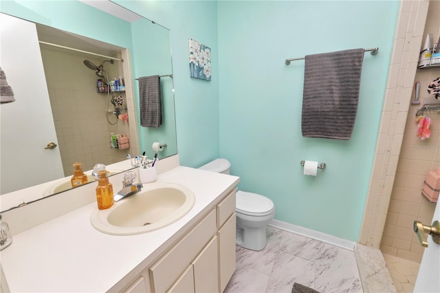 bathroom featuring tiled shower, vanity, and toilet