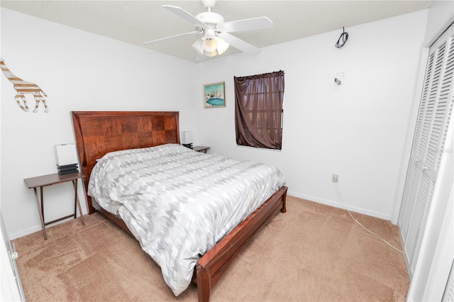 bedroom featuring ceiling fan, a closet, and light carpet