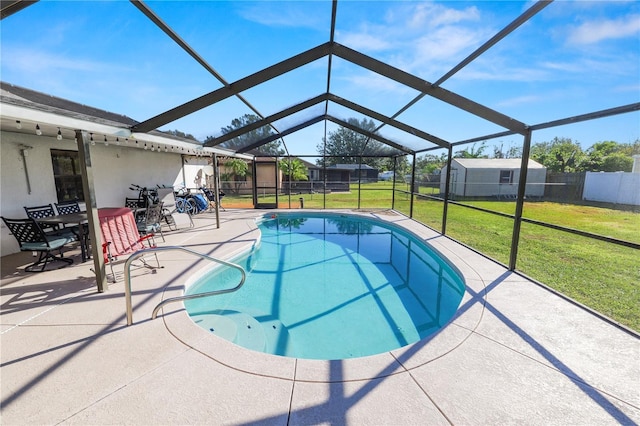 view of swimming pool featuring a lanai, a patio area, a yard, and a shed