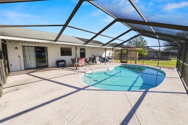 view of swimming pool with a lawn, glass enclosure, and a patio