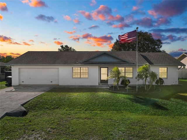 ranch-style home with a yard and a garage