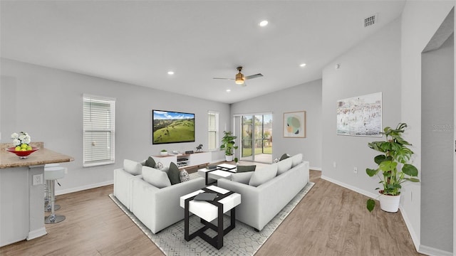 living room with light hardwood / wood-style floors, ceiling fan, and lofted ceiling