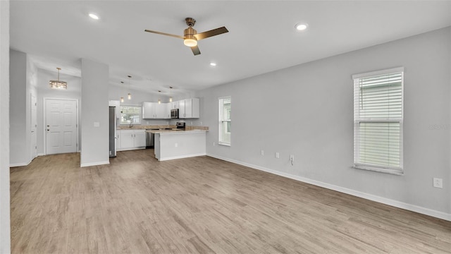 unfurnished living room featuring ceiling fan, plenty of natural light, and light hardwood / wood-style floors