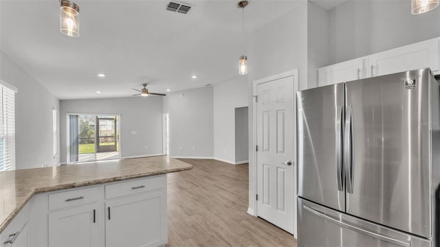 kitchen with stainless steel refrigerator, ceiling fan, white cabinets, and lofted ceiling