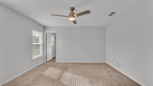 spare room featuring ceiling fan and light carpet