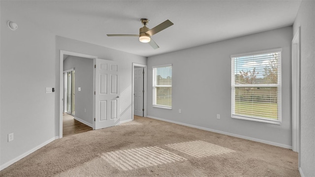 unfurnished bedroom with multiple windows, ceiling fan, and carpet floors