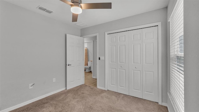 unfurnished bedroom with light carpet, a closet, and ceiling fan