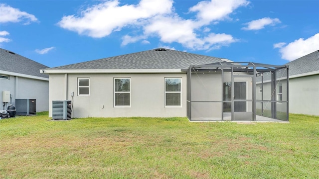 back of house with glass enclosure, cooling unit, and a lawn