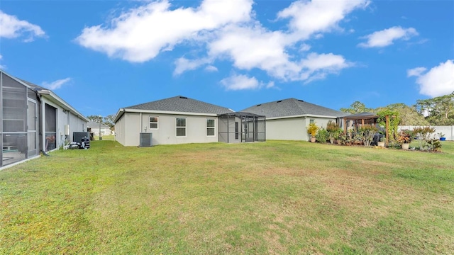 back of property featuring a lawn, a lanai, and central AC