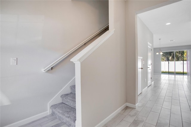 stairs with an inviting chandelier