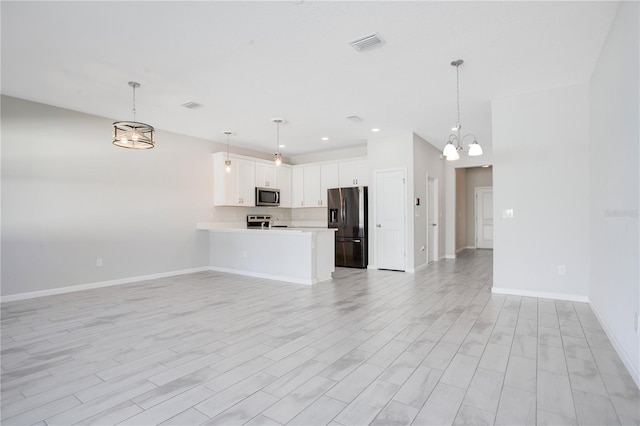 unfurnished living room featuring light hardwood / wood-style floors and an inviting chandelier