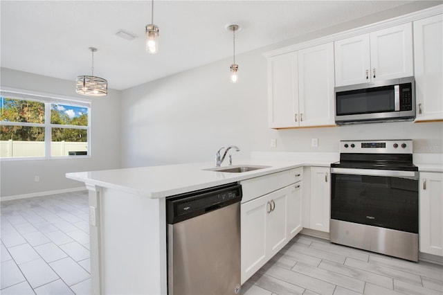 kitchen featuring sink, kitchen peninsula, stainless steel appliances, and hanging light fixtures