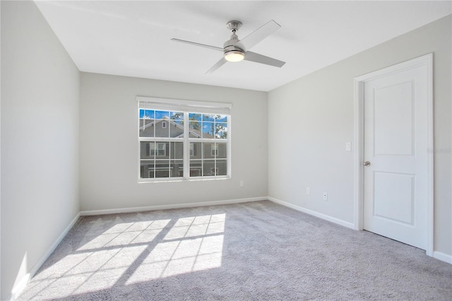 empty room with ceiling fan and light carpet