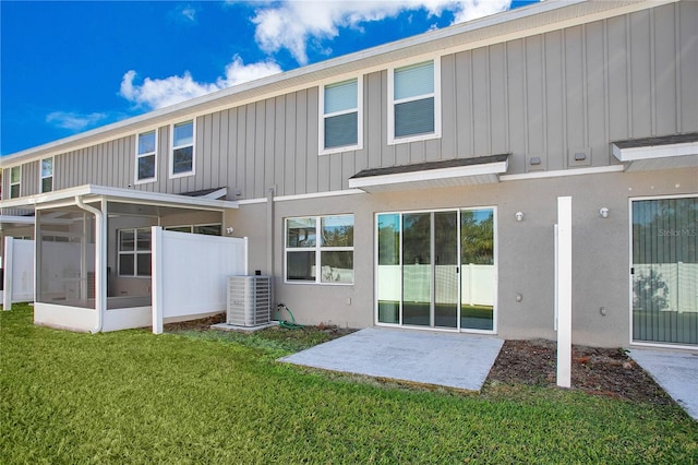 back of property featuring a lawn, a sunroom, and cooling unit