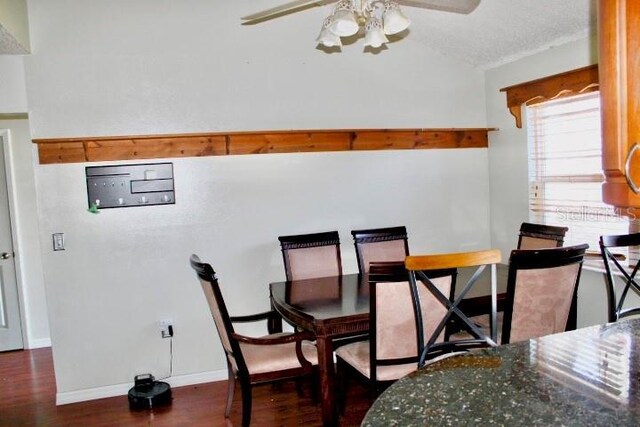 dining area with lofted ceiling, ceiling fan, a textured ceiling, and dark hardwood / wood-style floors