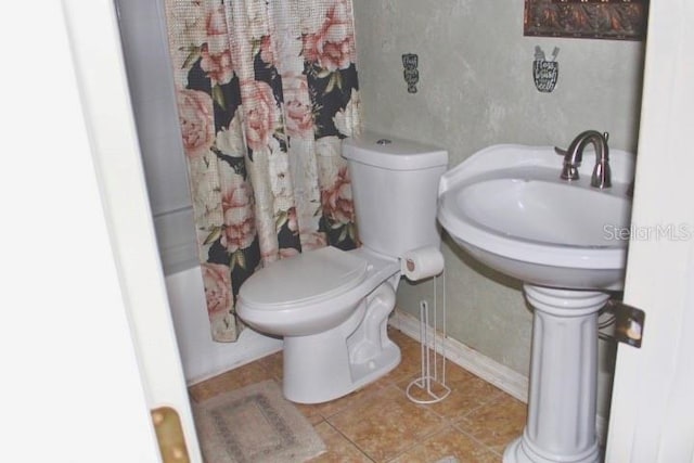 bathroom featuring tile patterned floors, toilet, and shower / tub combo