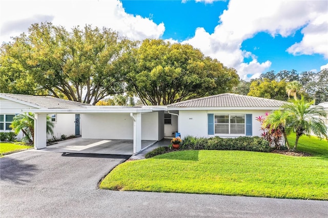 ranch-style home featuring a carport and a front yard