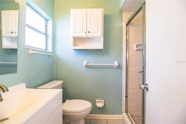 bathroom featuring tile patterned flooring, vanity, a shower with shower door, and toilet