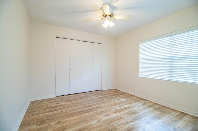 unfurnished bedroom with ceiling fan, light hardwood / wood-style floors, and a closet