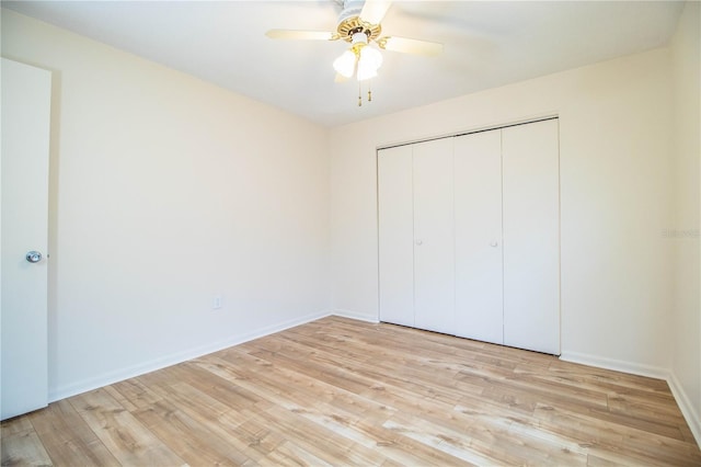 unfurnished bedroom featuring ceiling fan, a closet, and light wood-type flooring